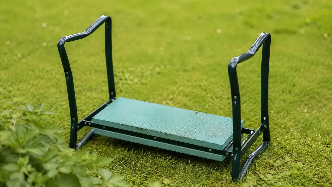 Empty garden kneeler bench sitting on grass with the padded side up, no user present